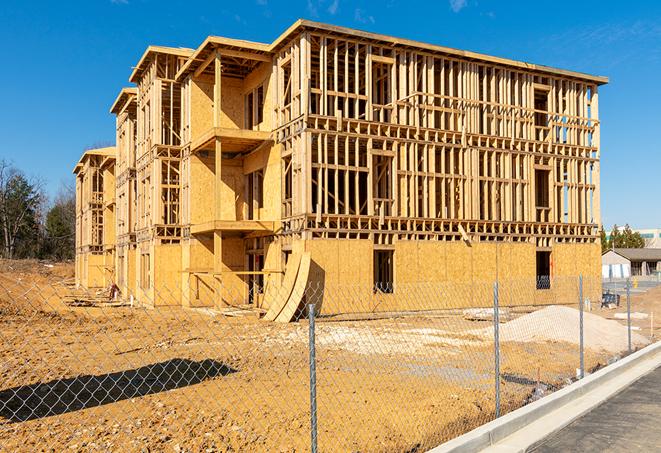 a construction site enclosed by temporary chain link fences, ensuring safety for workers and pedestrians in Harlingen, TX